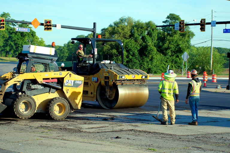 Construction crew resurfacing road with new layer of asphalt for infrastructure development